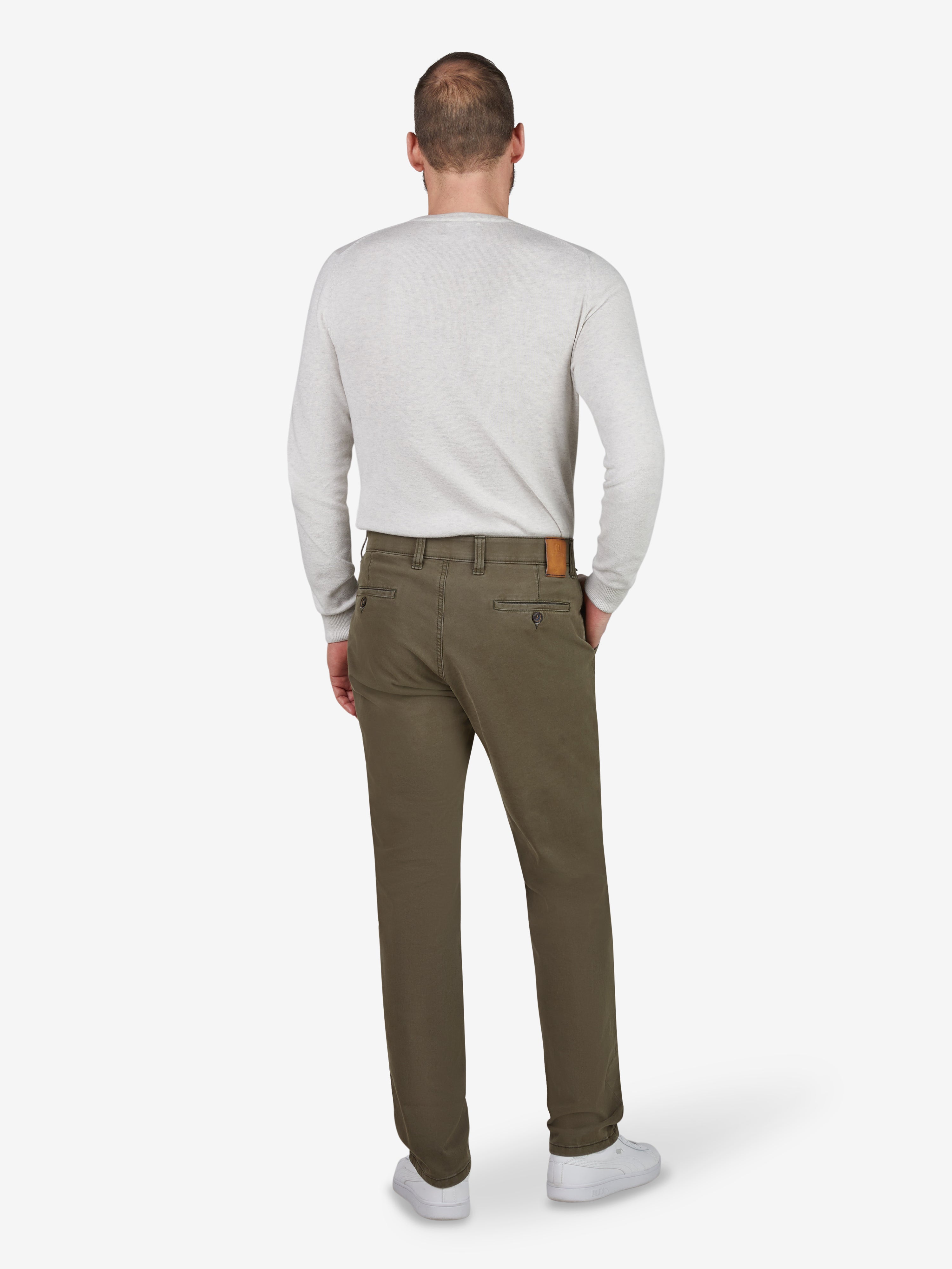 Ein Mann trägt eine grüne GARVEY 8070 Flat Front-Hose mit elastischem Komfortbund, Hemdstopper und Münztasche, gefertigt aus bi-elastischer Baumwoll-Qualität. Der Look ist bequem, sportlich und ideal für das Ganzjahres-Saison.