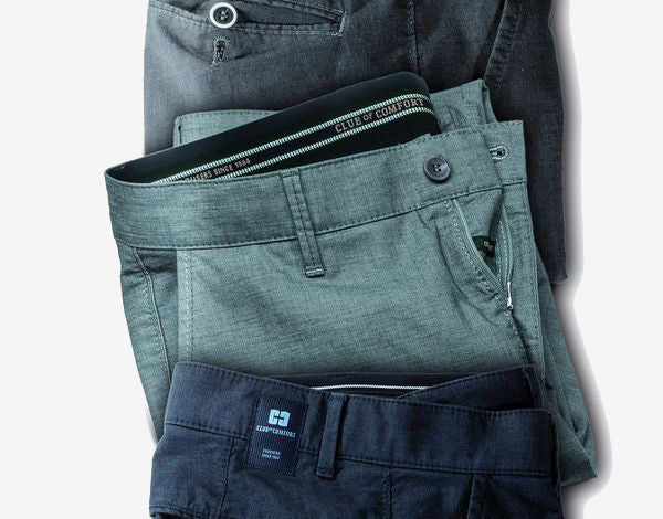 Drei Hosen in verschiedenen Farben: Dunkelgrau, hellblau und schwarz, aneinandergereiht. Die Hosen sind aus Stoff und haben Gürtel, Reißverschlüsse und Gürtelschlaufen.