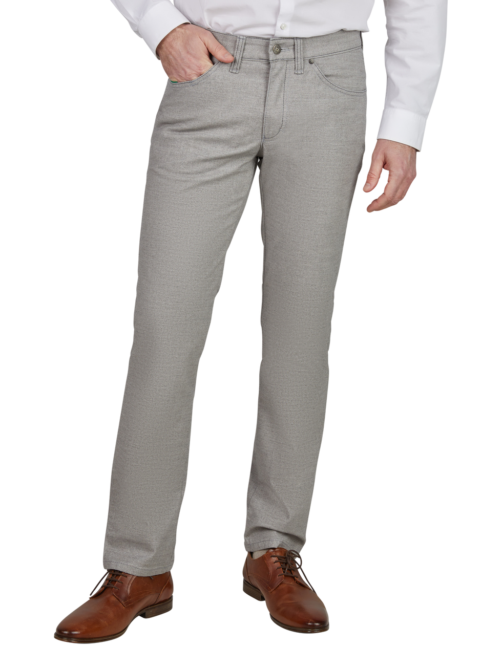 Mann trägt eine weiße Hemd und hellgraue, gerade geschnittene Stoffhose mit Gürtelschlaufen, die eine Hand in der Tasche hat. Er trägt braune Lederschuhe.