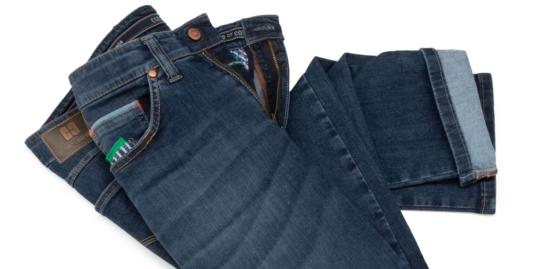Ein Stapel verschiedene Denim-Jeans in unterschiedlichen Blautönen, ordentlich gefaltet. Die Hosen sind auf einem weißen Hintergrund zu sehen, wobei einige mit sichtbaren Nieten, Taschen und Nähten versehen sind.