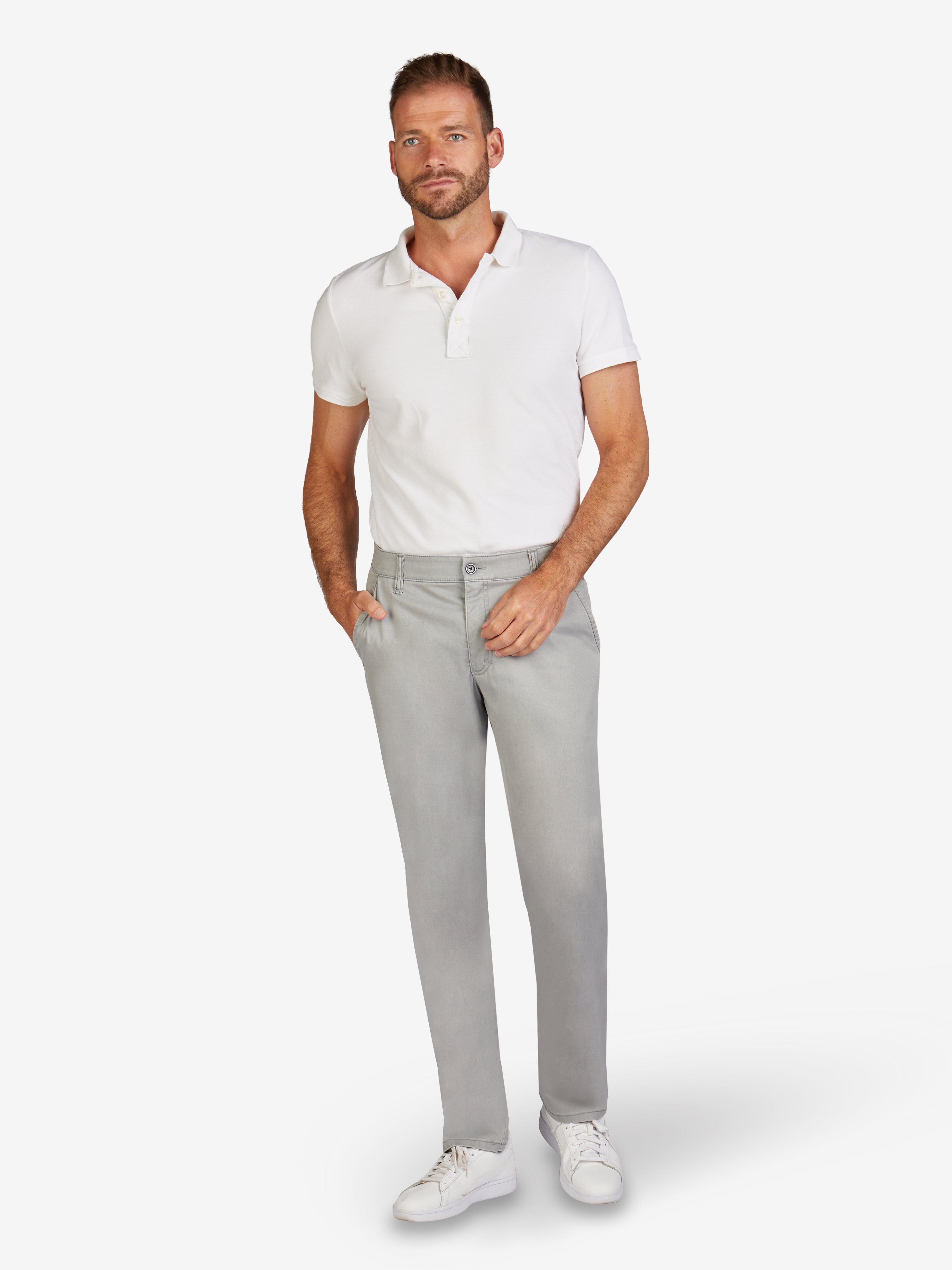 Mann trägt eine hellgraue DENVER 7901 Flat Front-Hose aus stretchiger Baumwolle mit Diamant-Finish, Komfortbund, Hemdenstopper, normaler Leibhöhe, geradem Bein, und Reißverschluss-Sicherheitstasche in grau, kombiniert mit weißem Polo-Shirt, weiße Sneakers, im weißen Hintergrund.