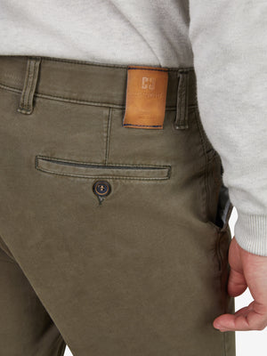 Nahaufnahme einer grünen Flat-Front-Hose von GARVEY, mit elastischem Komfortbund, Hemdstopper und Münztasche. Das Produkt hat einen normalen Leibhöhen, schmaleren Beinverlauf, hergestellt aus bi-elastischer Baumwolle, mit Label „Club of Comfort“ auf dem Bund.