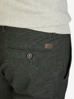 Nahaufnahme einer dunkelgrauen, melierten Flat-Front-Hose mit elastischem Komfortbund und Hemdstopper, hergestellt von Club of Comfort aus Baumwoll-Struktur-Mischgewebe mit Woll-Optik, reguläre Leibhöhe, schmaler Beinverlauf, mit eingestellter Gesäßtasche, sichtbare Details und Markenlogo.