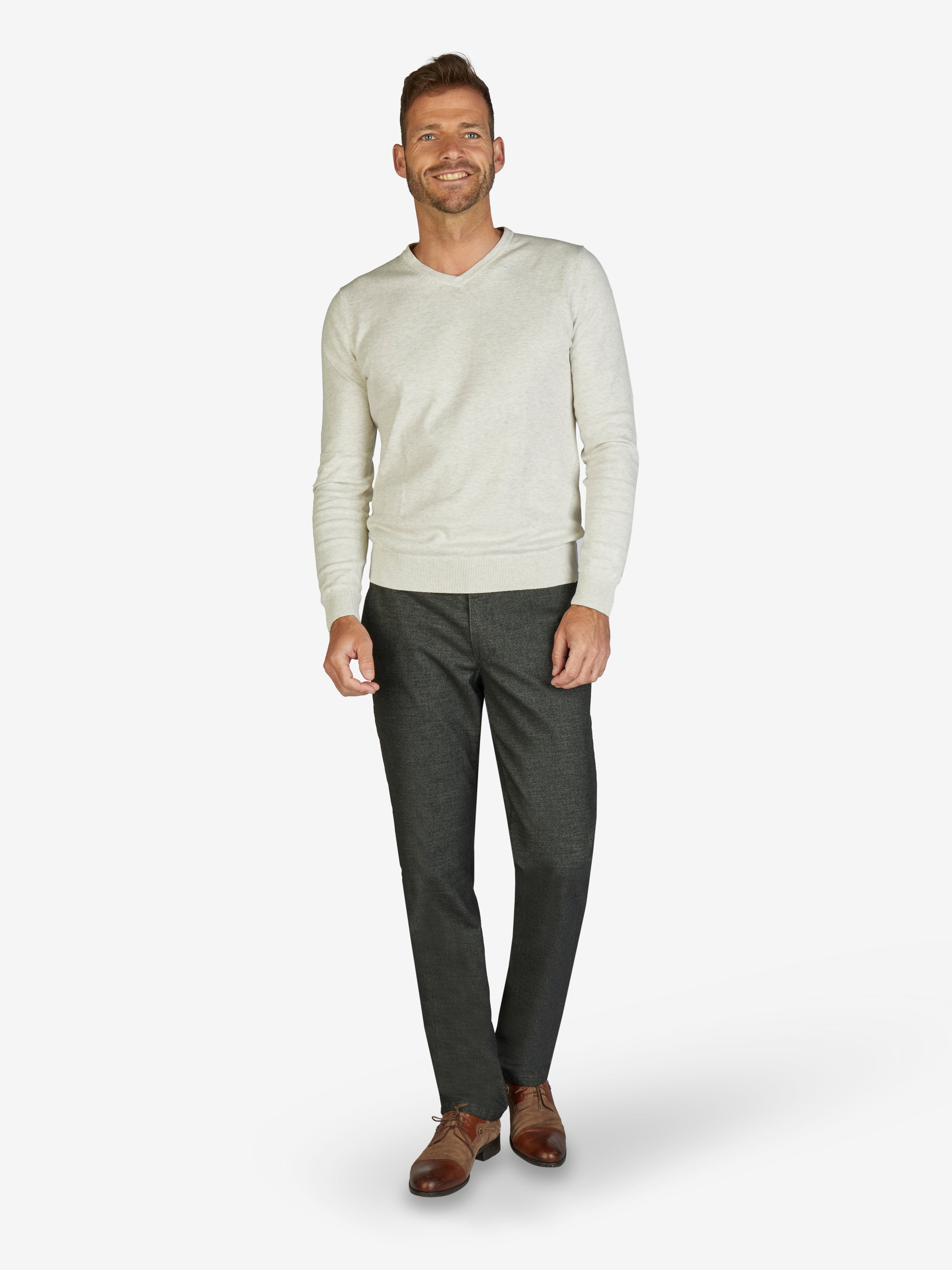 Mann trägt eine beige Baumwoll-Sweatshirt und dunkelgraue GARVEY Flat Front-Hose mit elastischem Komfortbund, Hemdstopper, Wool-Optik, schmaler Beinform und normaler Leibhöhe, geeignet für Herbst/Winter, auf weißem Hintergrund.