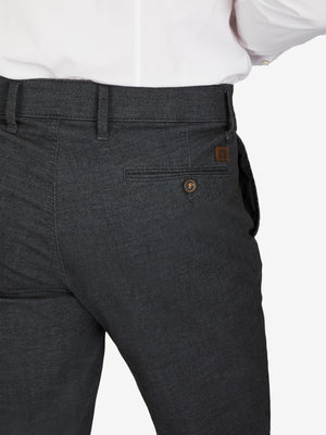 Nahaufnahme einer schwarzen Flat Front-Hose von GARVEY in Größe DE Kurz, hergestellt von Club of Comfort. Die Hose hat einen elastischen Komfortbund, eine schmale Fußweite und eine dezente kleine Logostickerei. Das Material ist Baumwoll-Struktur-Mischgewebe mit Woll-Optik, meliert in marine blau. Perfekt für Herbst/Winter, mit Stretch und OEKO-TEX Standard 100.