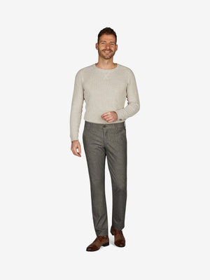 Männlicher Modell trägt eine graue GARVEY 7631 Flat Front-Hose mit elastischem Komfortbund und Hemdstopper, kombiniert mit einem cremefarbenen Pullover. Die Hose aus Baumwoll-Struktur-Mischgewebe zeigt eine Woll-Optik mit Melange-Effekt, normale Leibhöhe, schmalere Fußweite für schlanken Beinverlauf, geeignet für Herbst/Winter.