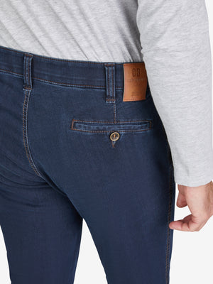 Nahaufnahme einer dunkelblauen GARVEY 7915 Flat Front-Hose mit elastischem Komfortbund, Hemdstopper und praktischer Bundverlängerung mit Knopf und Haken. Die Hose ist aus hoch elastischem Super High Stretch-Denim gefertigt, mit schmaler Beinweite, normaler Leibhöhe und sichtbarem grauem Oberteil.