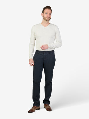 Mann trägt eine dunkelblaue GARVEY 8025 Flat Front-Hose mit elastischem Komfortbund, Hemdenstopper und High Stretch Baumwolle mit Thermolite-Wärmeisolierung, kombiniert mit einem weißen Pullover.