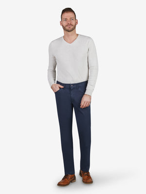 Mann trägt eine helle, langärmlige Sweater mit modernen, dunklen MARVIN 8225 Thermo-Hosen in Blau, schlanke Passform, mit elastischem Komfortbund, Hemdstopper, Münztasche mit Kontrast, aus High Stretch-Baumwolle mit Thermolite-Wärmeisolierung, hergestellt von Club of Comfort.