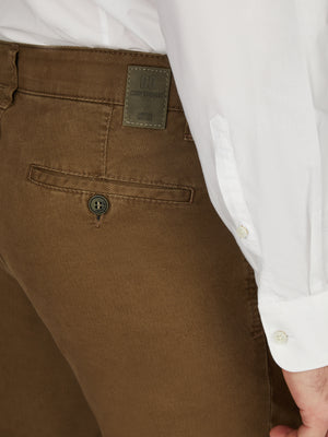 Nahaufnahme einer braunen Hose "MARVIN 8011" von Club of Comfort mit elastischem Komfortbund, Hemdenstopper und Münztasche mit Kontrast, gefertigt aus High Stretch Baumwolle mit winterlichem Struktur-Print, normaler Leibhöhe, schlankes Bein, zeigt die rückseitige Tasche mit Knopf.