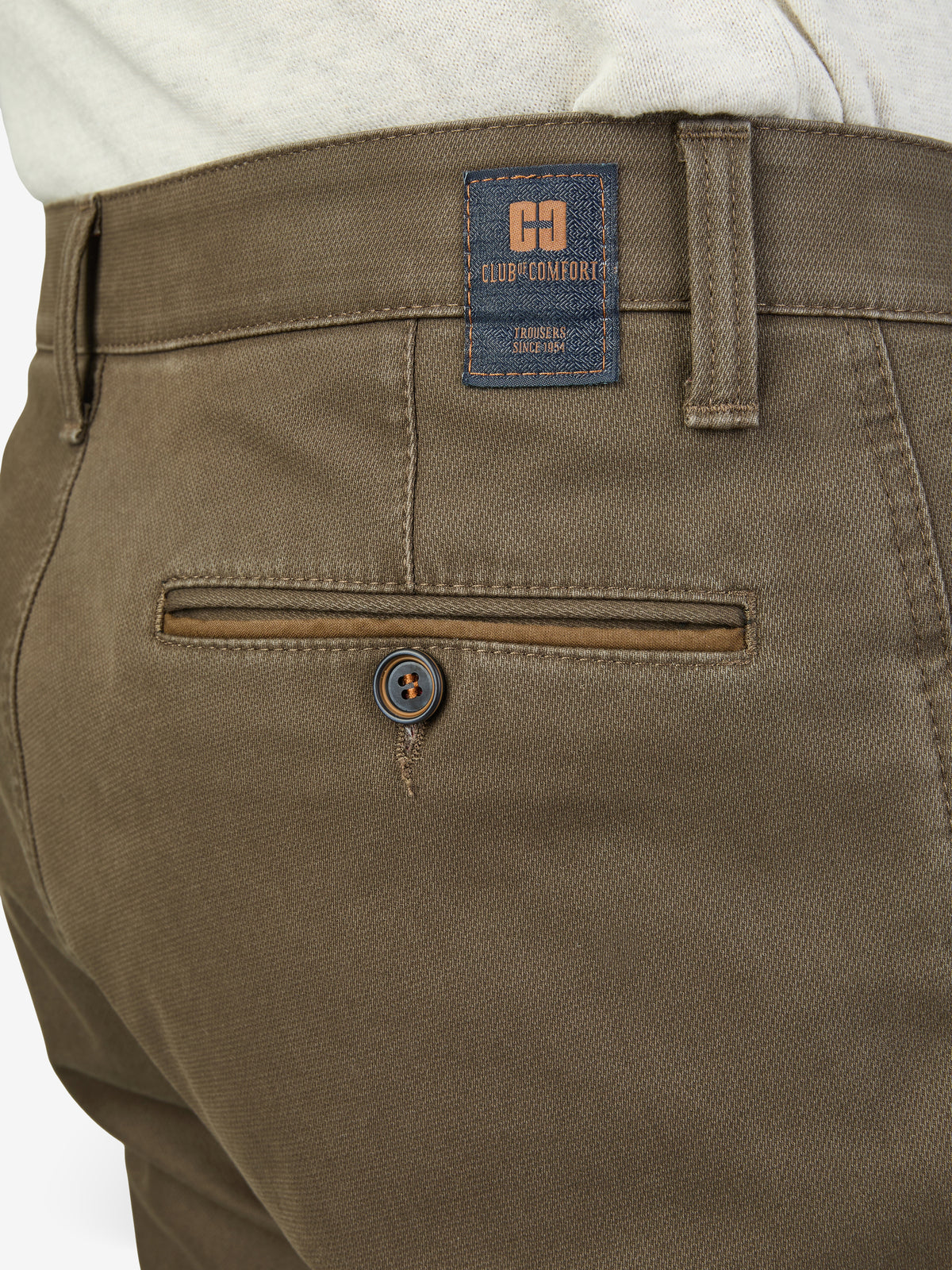 Nahaufnahme der beigen MARVIN 8025 Hose von Club of Comfort, zeigt den elastischen Comfortbund, die Swing-Pocket mit Hemdstopper, eine doppelt paspelierte Münztasche und den Markenetikett. Hergestellt aus High Stretch Baumwolle mit Thermolite-Wärmeisolierung, normaler Leibhöhe, schmalem Bein und modifizierter 5-Pocket-Form.