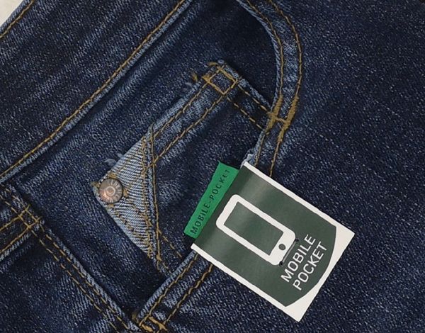 Nahaufnahme eines dunkelblauen Denim-Jeans mit einem green und weißen Preisschild, das auf den Begriff "Mobile Pocket" hinweist und ein Smartphone-Icon zeigt.