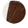 Nahaufnahme eines braunen Cordhosenstoffs mit sichtbarer Tasche und Nähte, detailreiche Textur des samtartigen Materials deutlich erkennbar.